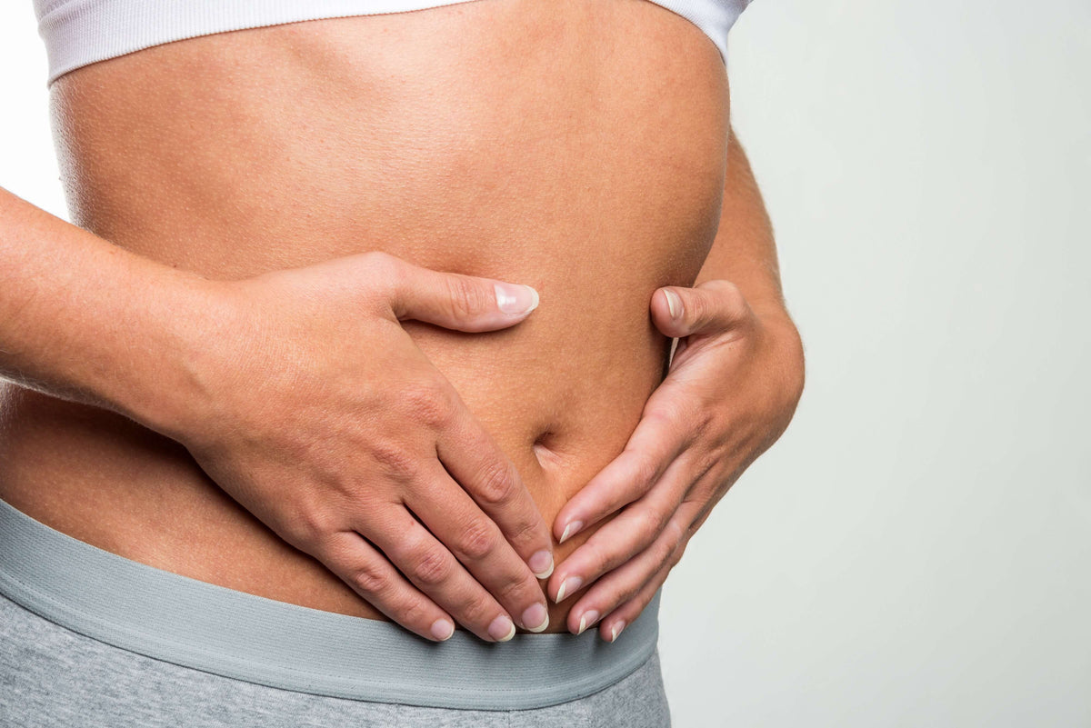 Frau hält sich Bauch - Darmkrebs vorbeugen