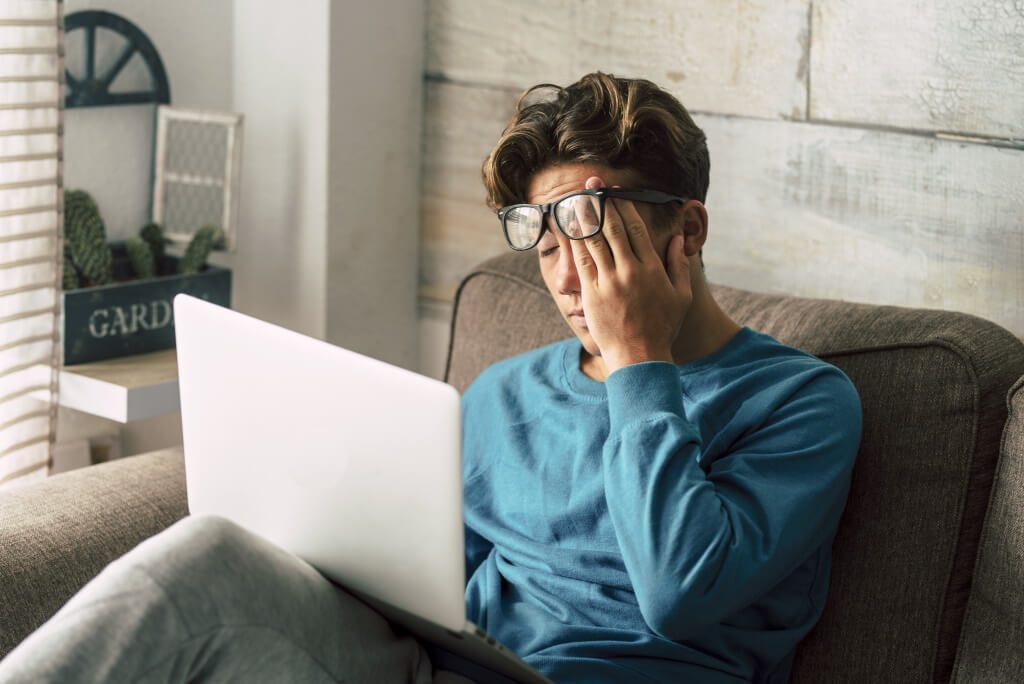 Risiko für Depression: Mann mit Laptop leidet unter beruflichem Stress
