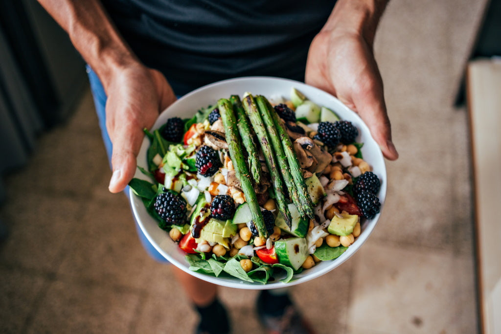 Gesunde Ernährung: Bowl mit Salat, Beeren, Hülsenfrüchten und Gemüse