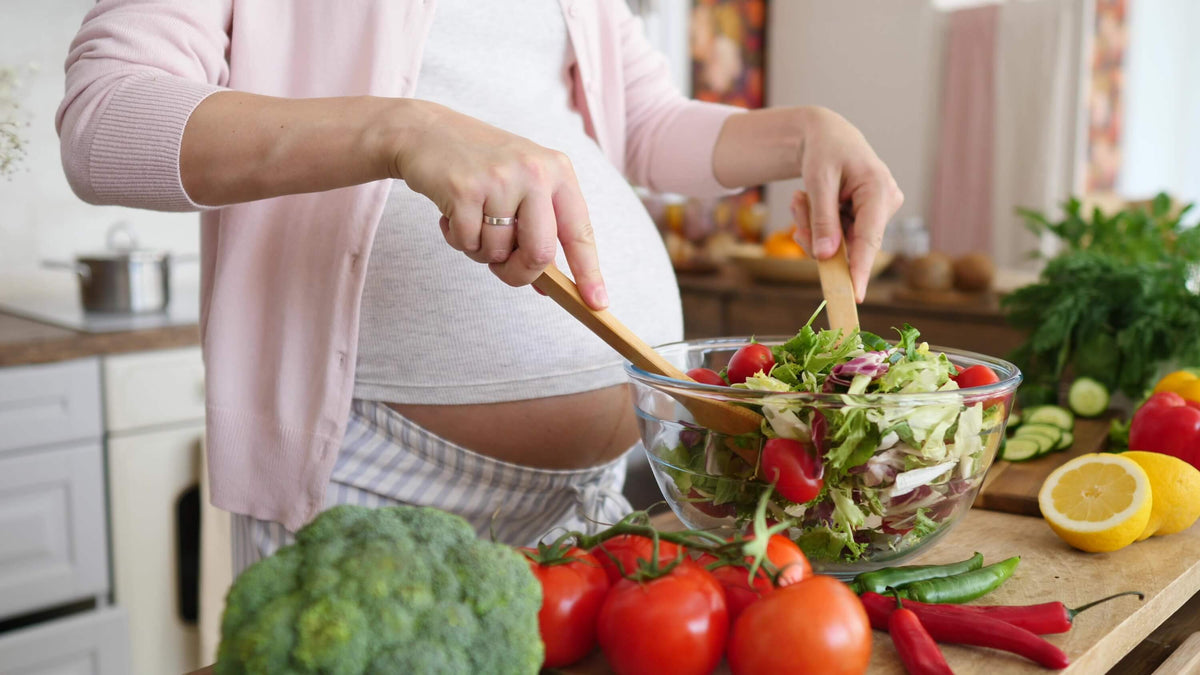 Schwangere Frau bereitet Salat zu - Magnesium in der Schwangerschaft