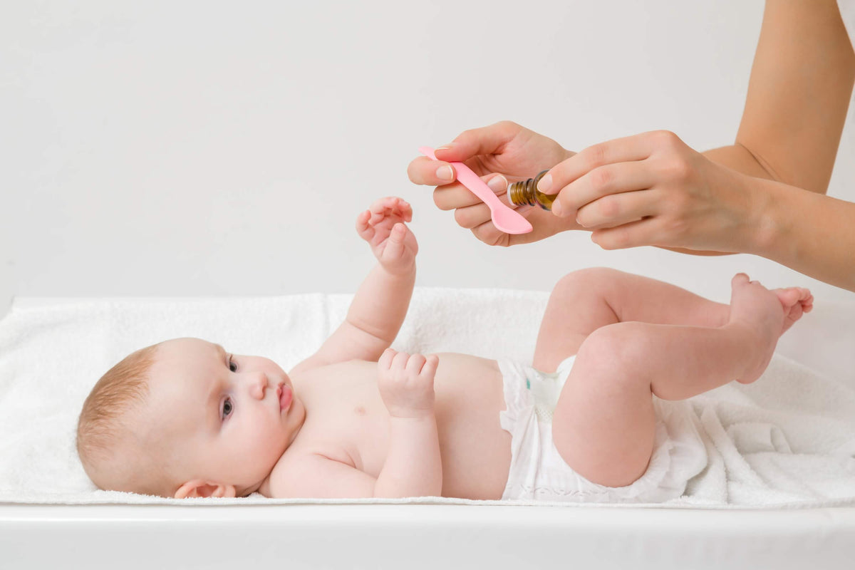 Mutter verabreicht Ihrem Baby Vitamin-D-Tropfen