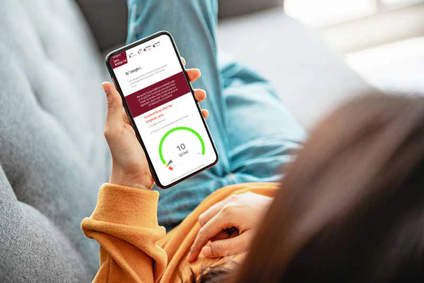 Frau schaut auf Smartphone, das die Ergebnisse des PSA Tests zeigt